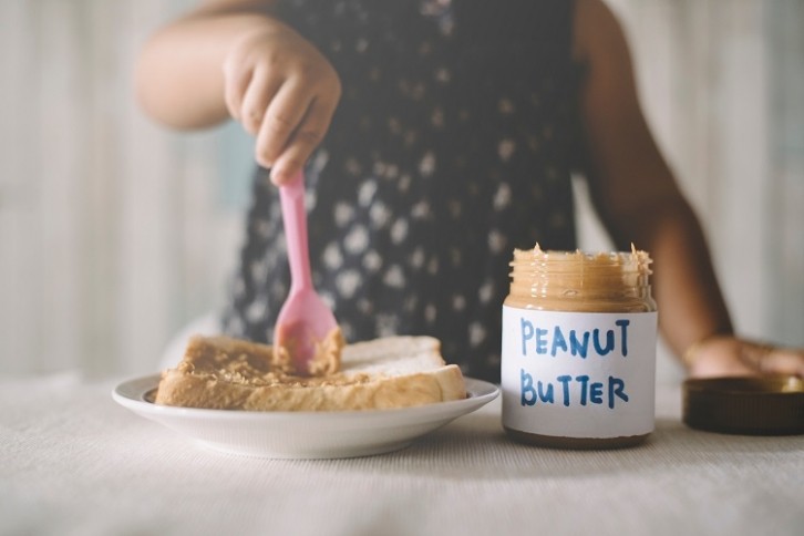 Girl eating peanut butter - GettyImages-Hafiez Razali